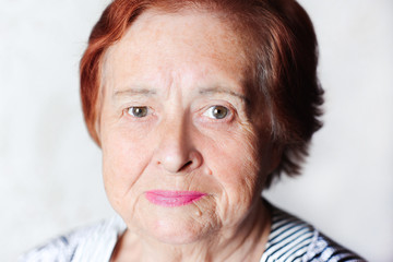 Elderly woman smiling indoors. Looking at camera. Senior female.