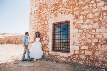 Obraz na płótnie Canvas couple in love, bride and groom standing near the stone wall