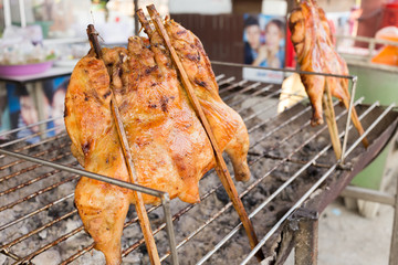Naklejka premium hot roasting chicken on smoked grill barbecue