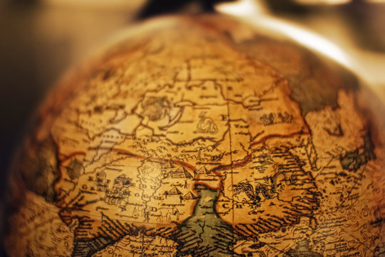 Close up of old vintage globe with old handmade map soft colors