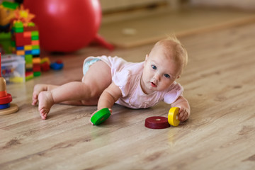 baby with toys on the floor