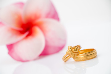 Fototapeta na wymiar wedding ring with Plumeria flower on white bakcground (Love concept)