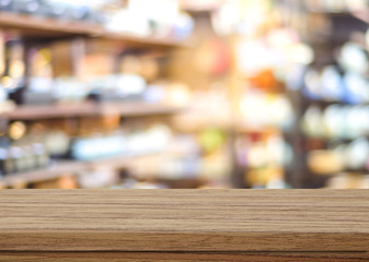 Empty table over blur product shelf in supermarket with bokeh ba