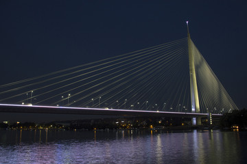Cable bridge, named ADA BRIDGE, spanning the Sava river at night