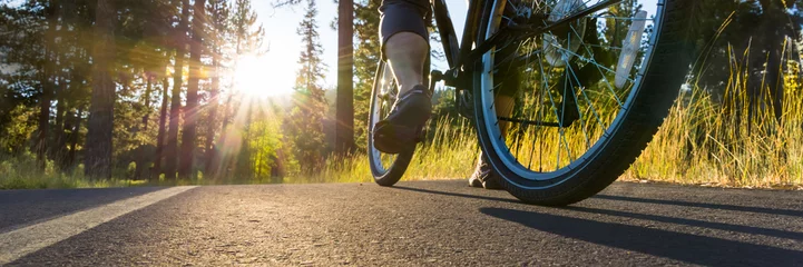Foto auf Acrylglas Fahrräder Fahrrad auf dem von der Sonne beleuchteten Asphaltweg.