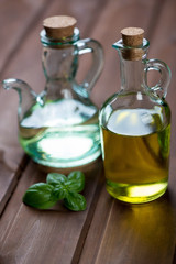 Obraz na płótnie Canvas Two glass bottles with olive oil, studio shot, close-up