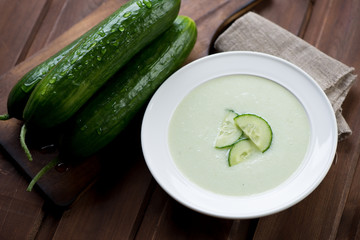 Cucumber soup and fresh cucumbers, selective focus, close-up