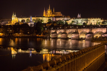 Reflection of Prague caste and the Charles bridge at dusk