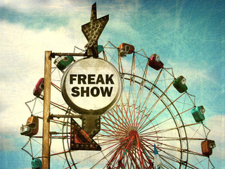 aged and worn vintage photo of freak show sign at carnival