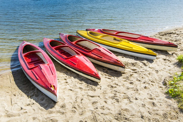 Colorful kayaks moored on lakeshore, Goldopiwo Lake, Mazury, Pol