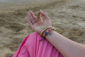 Om-Zeichen am Unterarm einer jungen Frau beim Yoga