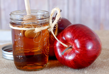 Red apple and golden honey in rustic setting 