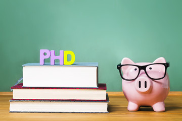 PhD degree theme with textbooks and piggy bank with glasses - obrazy, fototapety, plakaty