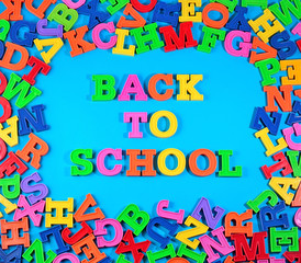 Back to school written by plastic colorful letters on a blue