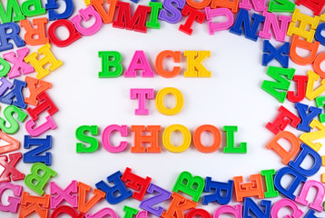 Back to school written by plastic colorful letters on a white