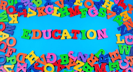 Education written by plastic colorful letters on a blue