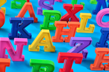 Plastic colorful alphabet letters close up on a blue