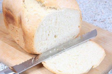 sliced white bread on wooden board and knife
