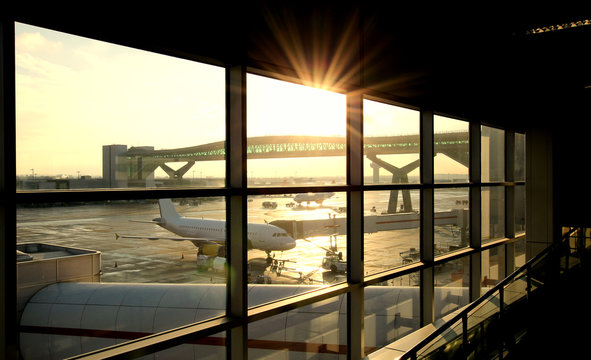 Fototapeta Airport departure lounge with passenger plane being loaded.    