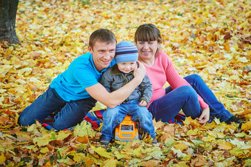 Young family walking in autumn park
