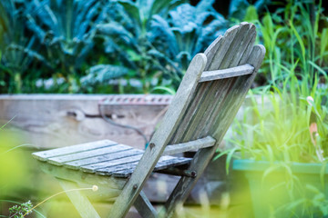 Lonely old porch chair in green garden