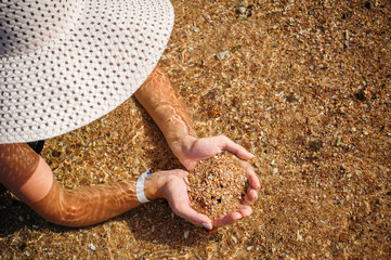 young woman in a big hat holding a sand
