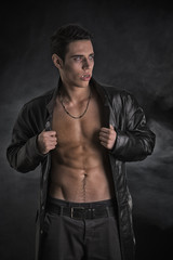 Fototapeta na wymiar Young Vampire Man in an Open Black Leather Jacket, Showing Chest