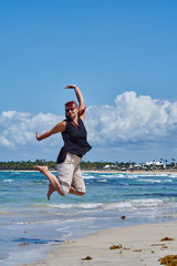 Obraz premium Frau am kribischen Strand springt in die Luft