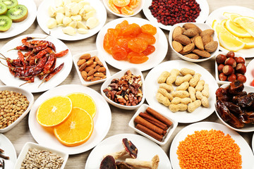 Different products on saucers on wooden table, closeup