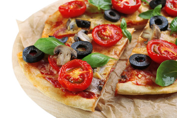 Tasty pizza with vegetables and basil on cutting board close up