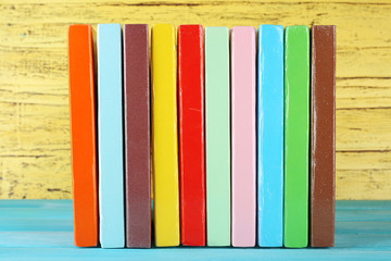 Colorful books on yellow wooden background