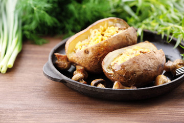 Baked potatoes with cheese and mushrooms on table close up