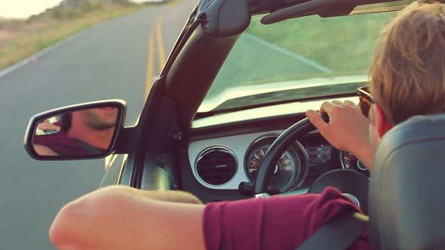 Happy Young Man Driving Convertible on Country Road. Steadicam Shot. 