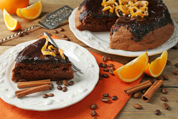 Cake with Chocolate Glaze and orange on plate, on wooden background