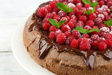 Cake with Chocolate Glaze and raspberries on wooden background