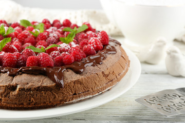 Cake with Chocolate Glaze and raspberries on color wooden background