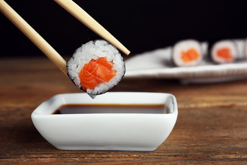 Dipping roll in sauce on wooden table