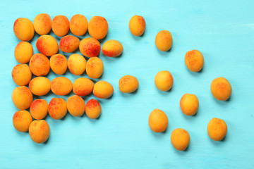 Fototapeta na wymiar Ripe apricots on color wooden background