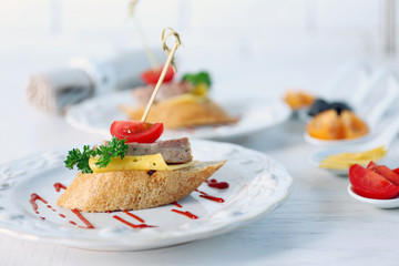 Tasty canapes on wooden table, close up