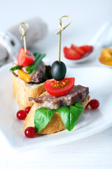 Tasty canapes on wooden table, close up