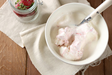 Delicious vanilla ice cream in bowl and frozen berries, on wooden background