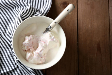 Delicious vanilla ice cream in bowl and frozen berries, on wooden background