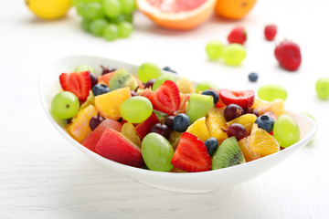Fresh fruit salad on white wooden table