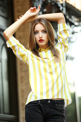 Beautiful young girl posing on city street