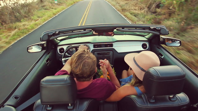 Happy Mixed Race Couple Driving Convertible on Country Road. Romantic Freedom Love Concept. Latina Woman from South America and Caucasian Man.