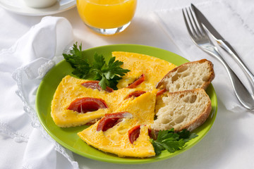 Omelette with tomatoes, served with fresh bread, orange juice, a cup of coffee for breakfast