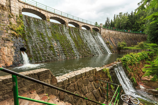 Karpacz w Karkonoszach - Zapora na Łomnicy, p&oacute;łkolista , z pięcioma przelewami, na rzece Łomnica. Zbudowana jest z granitowych blok&oacute;w, korona ma długość około 105 m, powstała w latach 1910 &ndash; 1915