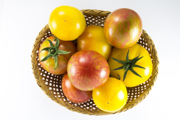 Red and yellow tomatoes in wicker oval shape