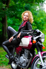 Naklejka na ściany i meble Biker girl in leather jacket on a motorcycle