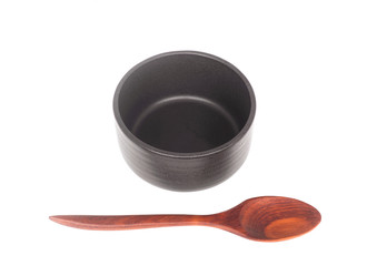 Black ceramic bowl with wooden spoon isolated